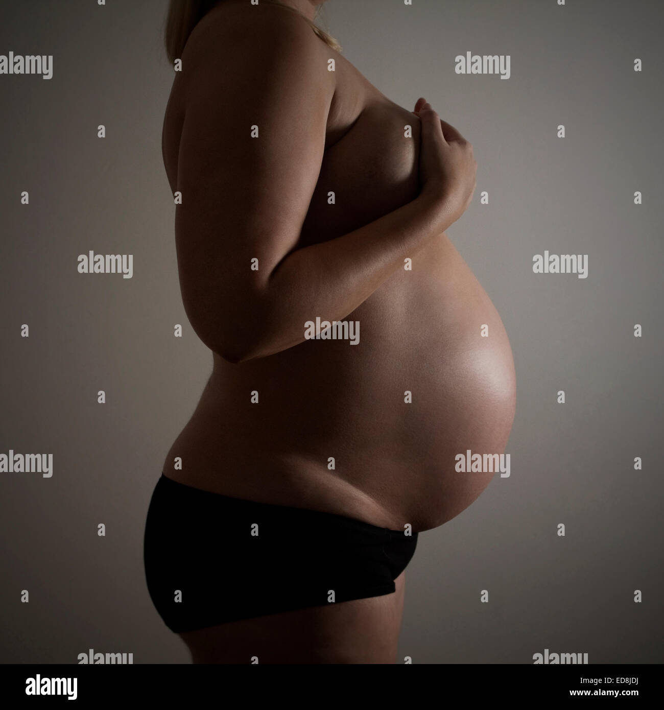 Side Shot di pesantemente la donna incinta a 37 settimane di gestazione Foto Stock