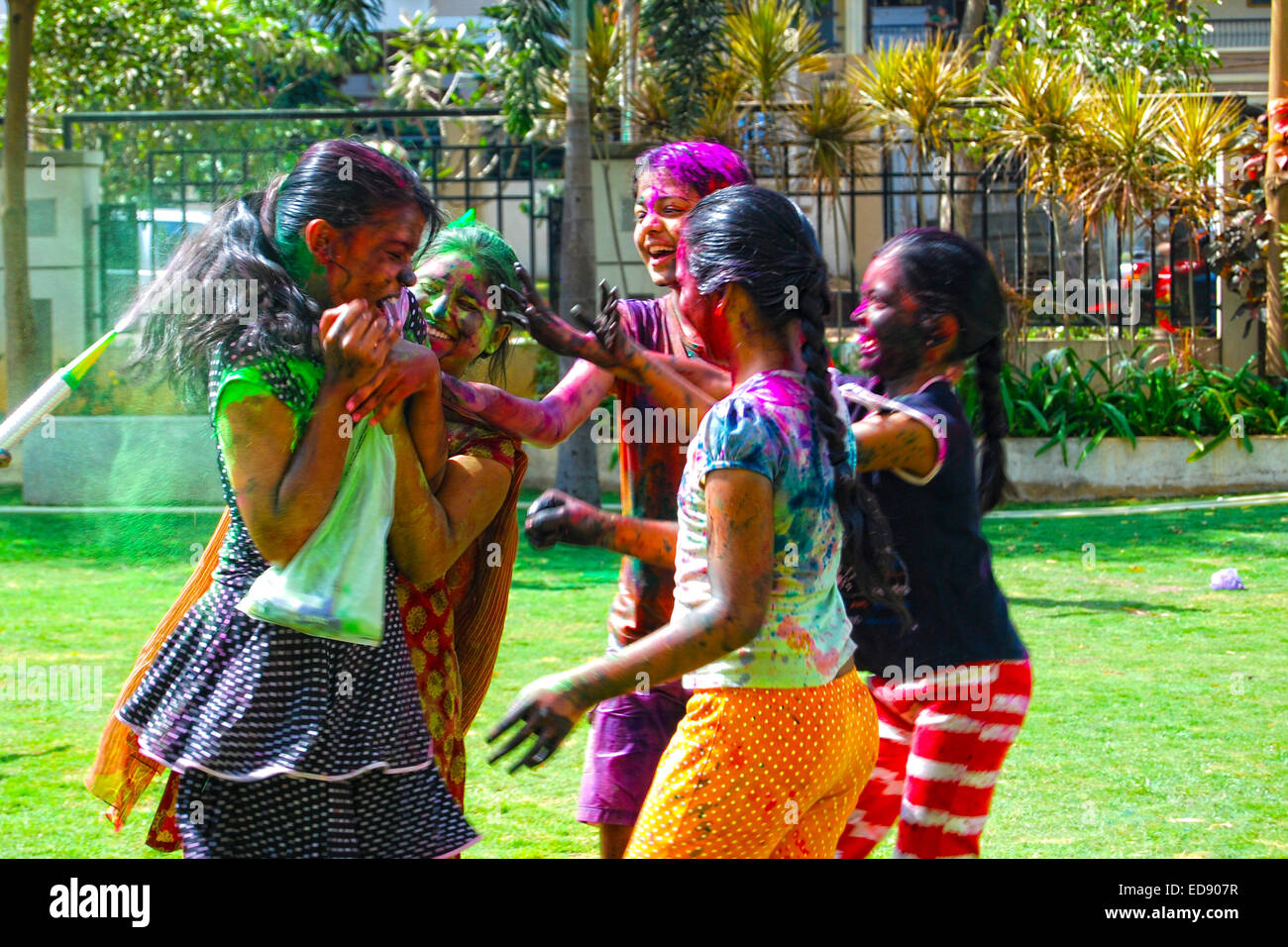 Un gruppo di giovani ragazze a giocare con i colori in polvere e acqua durante la primavera festival indù Holi noto anche come un festival di colori Foto Stock