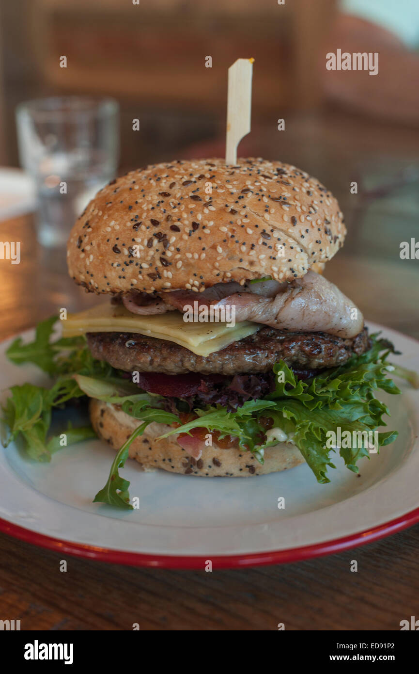 Australian hamburger con "La Partita" (lattuga, pomodoro, cipolla, formaggio, pancetta, uova fritte e barbabietole) servita su un seminate bun. Foto Stock