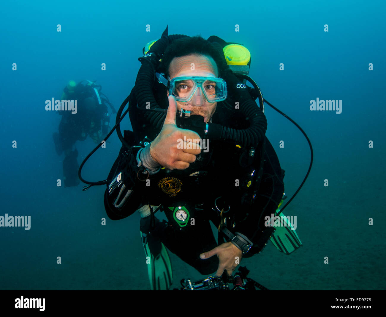 Subacquea segni mano scuba diver dimostra il linguaggio gestuale per i subacquei. Ascend, o io vado fino: un pugno è realizzato con una h Foto Stock