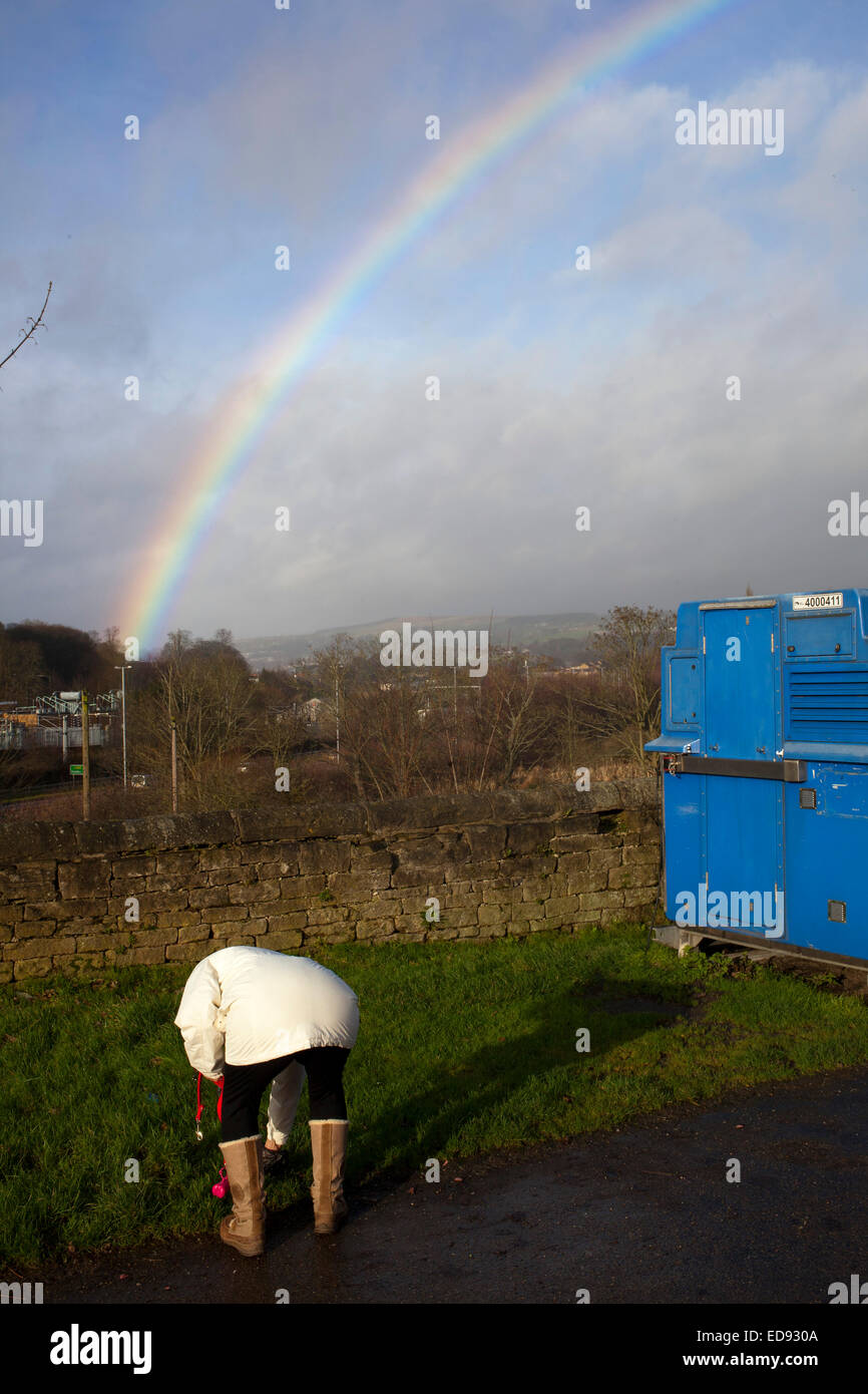 Titolare di una pensione o di una rendita preleva escrementi di cane come un arcobaleno di archi in tutta la città dello Yorkshire di Bingley in Inghilterra settentrionale. Foto Stock