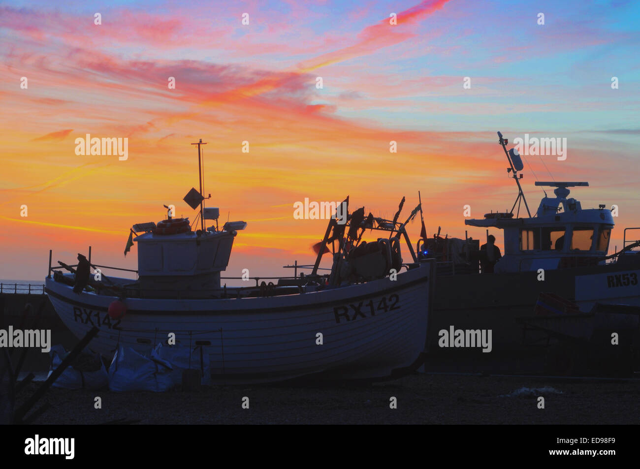 Hastings, East Sussex, Regno Unito. Il 2 gennaio, 2015. Glorioso tramonto su Hastings flotta da pesca sulla East Sussex costa. David Burr/Alamy Live News Foto Stock