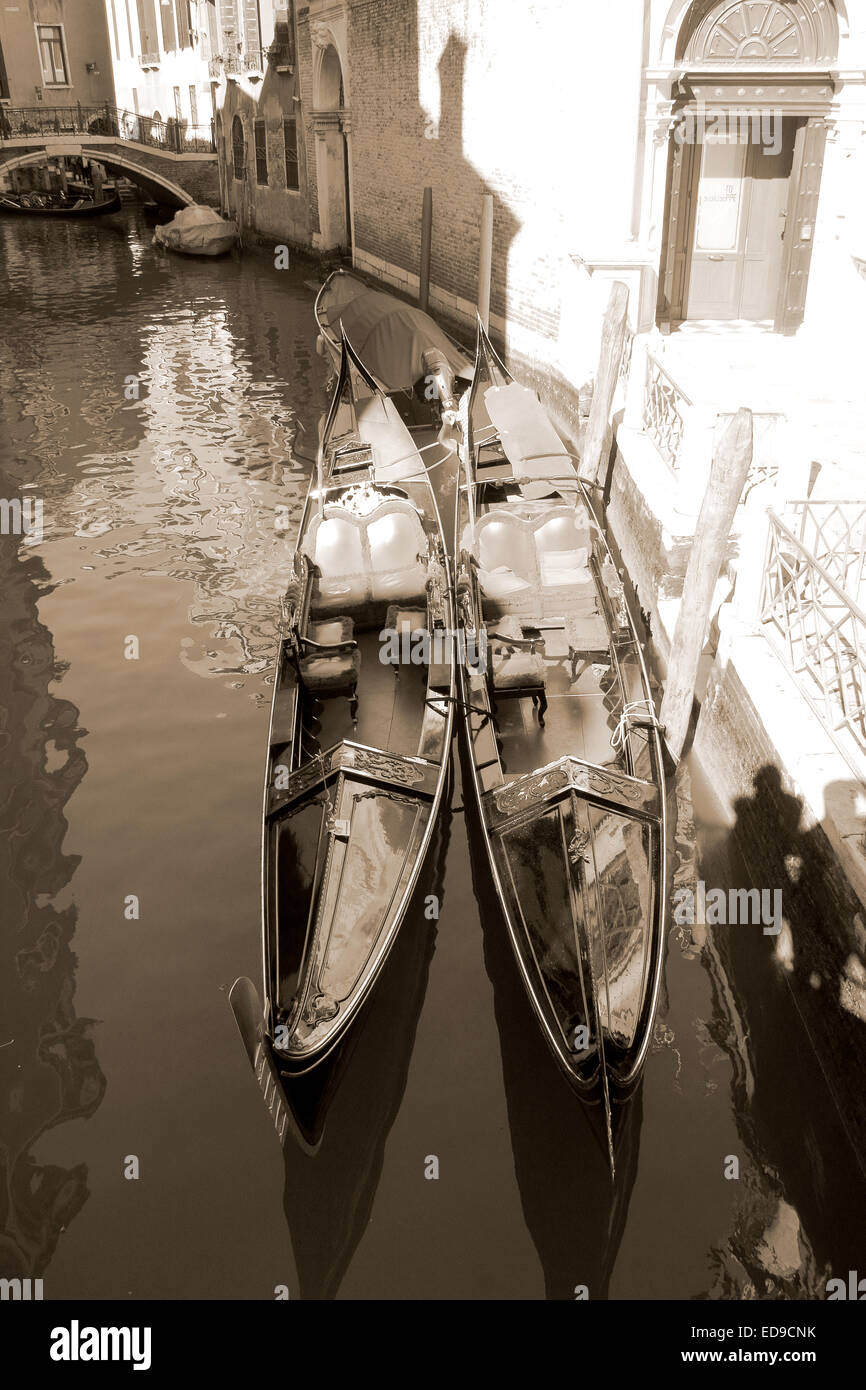 Coppia di gondole ormeggiata in un canale di Venezia, Italia. La fotografia in tonalità seppia Foto Stock