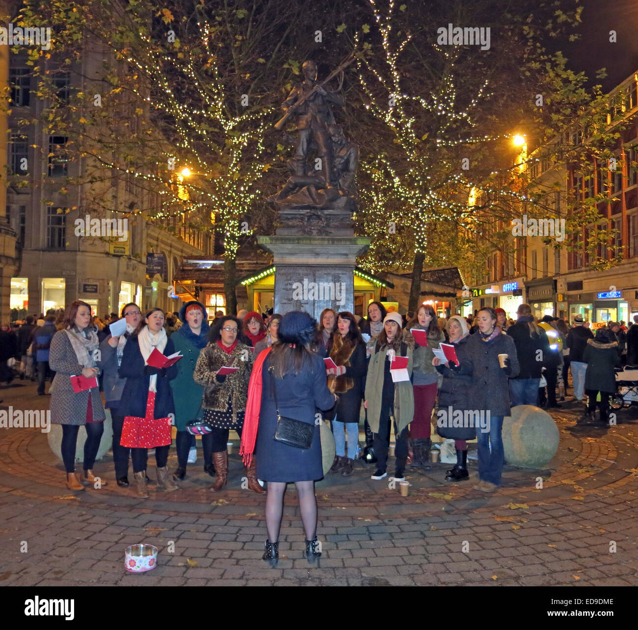 Carol tradizionali cantanti Manchester St Annes Sq, Inghilterra, Regno Unito durante la notte Foto Stock