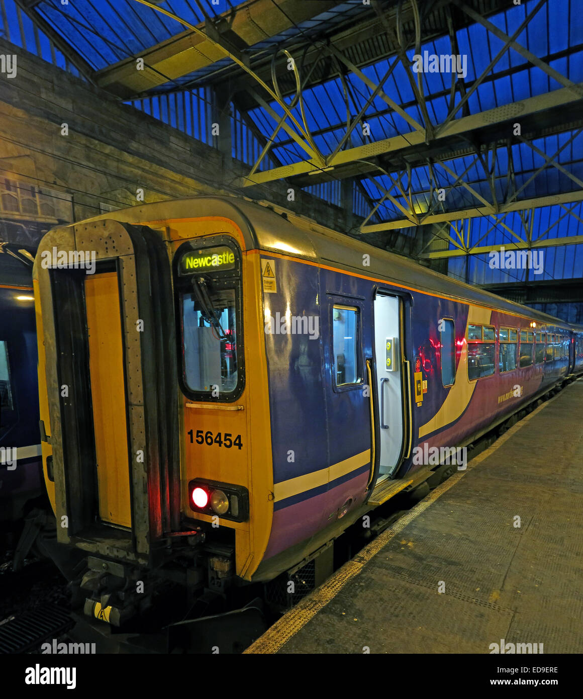 Treno di Newcastle a Carlisle stazione ferroviaria al crepuscolo, nell'Inghilterra del Nord Foto Stock