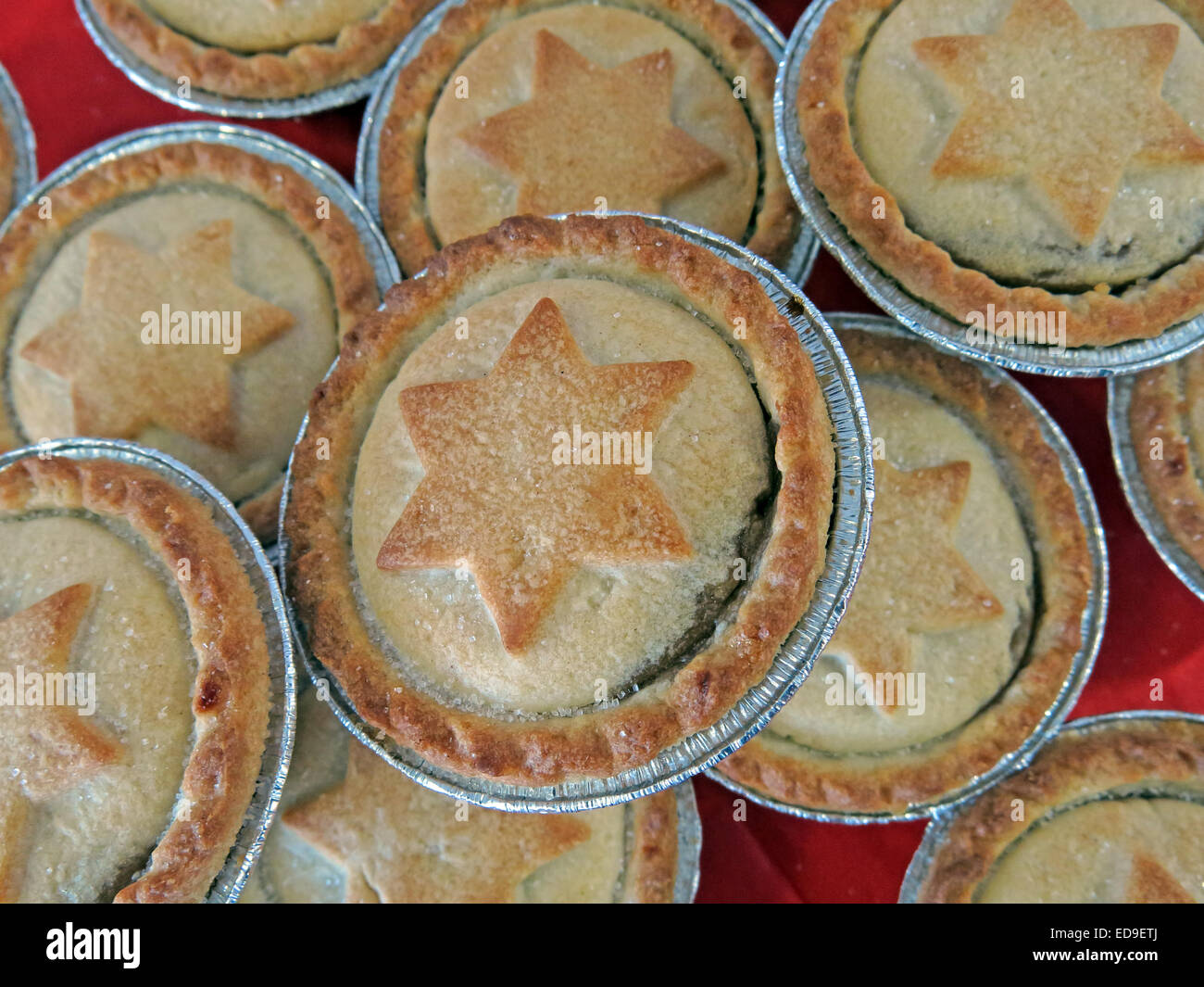 Dolci pasticci di carne macinata con la stella di Davide in pasticceria a Xmas su una tabella rossa Foto Stock
