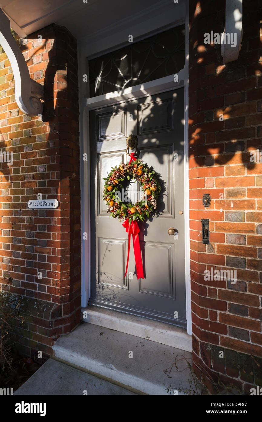 Festa di Natale corona sulla porta anteriore della vecchia canonica a Stockbridge, un villaggio o una piccola cittadina nella valle di prova, west Hampshire, Regno Unito Foto Stock