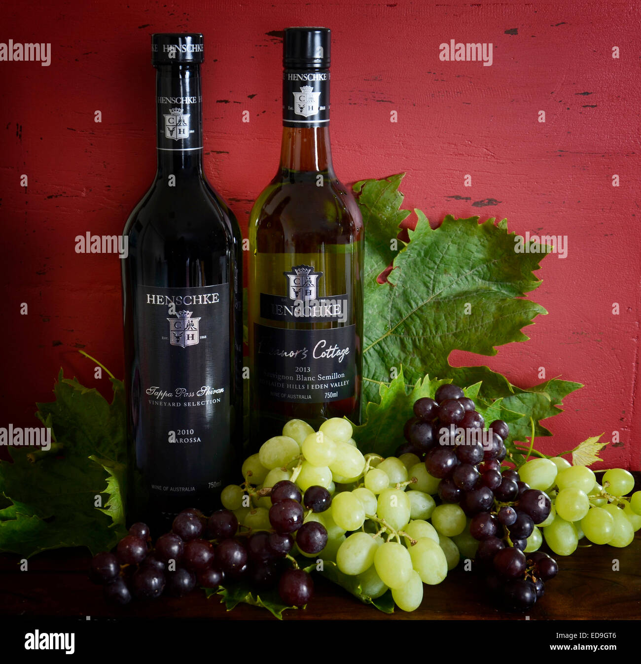 Premio Australiano di esportazione di vino di qualità con bottiglie di Henschke vino rosso e bianco su rosso scuro dello sfondo di legno Foto Stock