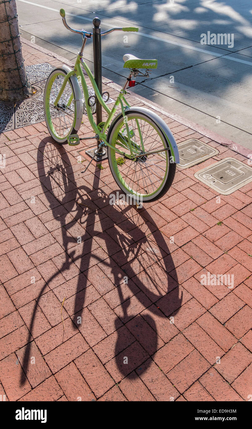Un beach cruiser bicicletta ad un portabicicletta su un marciapiede di mattoni su State Street a Santa Barbara in California Foto Stock