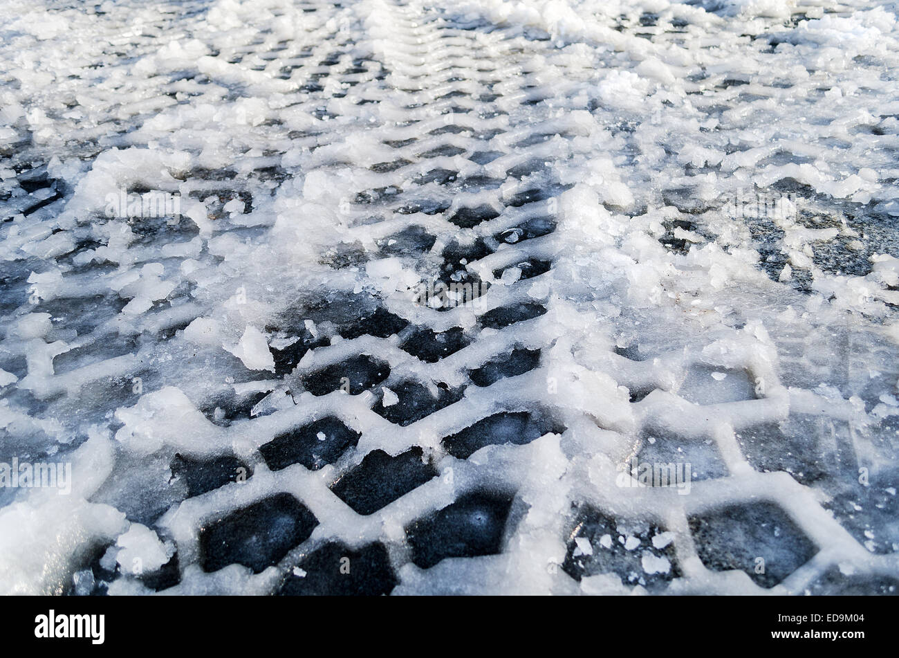 Close up del pneumatico via nella neve e nel ghiaccio terra Foto Stock