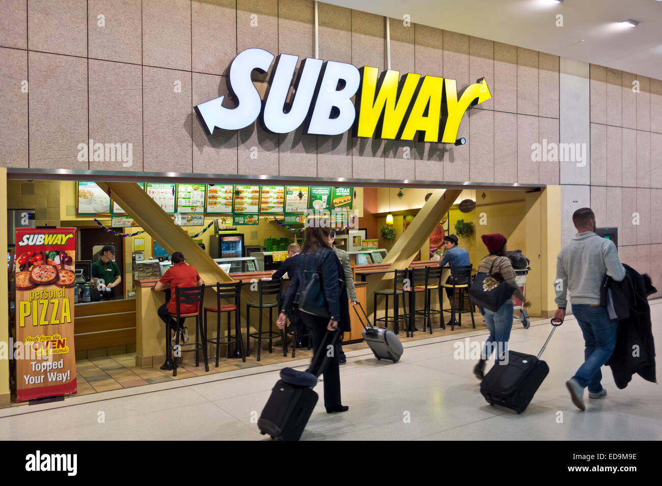 I viaggiatori di aria con le valigie passare da un sandwich di metropolitana ristorante all'Aeroporto di Toronto, Canada. Pasti veloci. Foto Stock