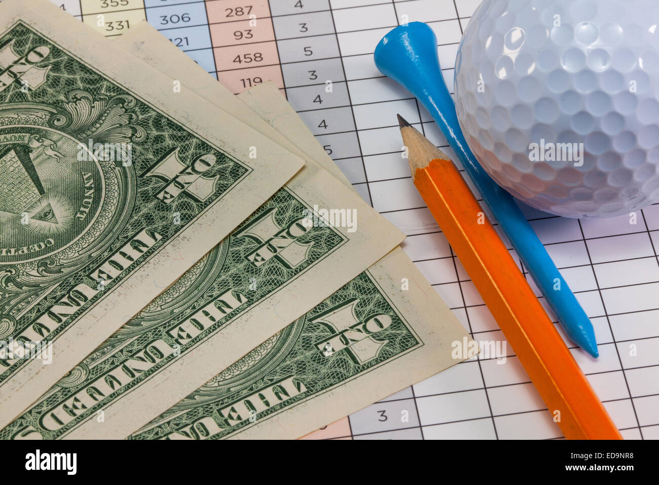 Us dollar banconote e attrezzature da golf giacente su di un campo da golf score card Foto Stock