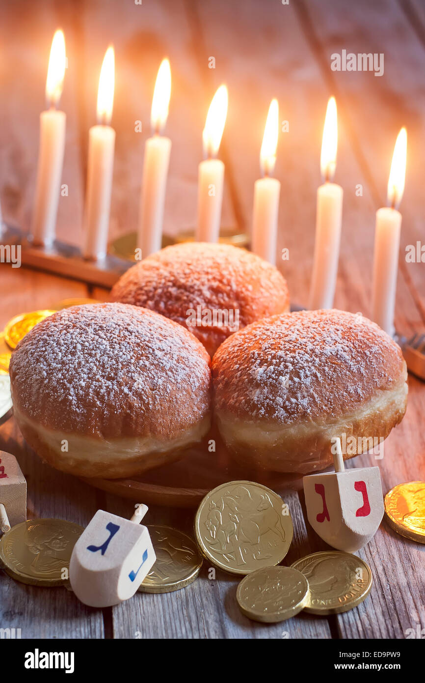 Festa ebraica hannukah simboli - menorah, ciambelle, chockolate monete e dreidels in legno. Foto Stock