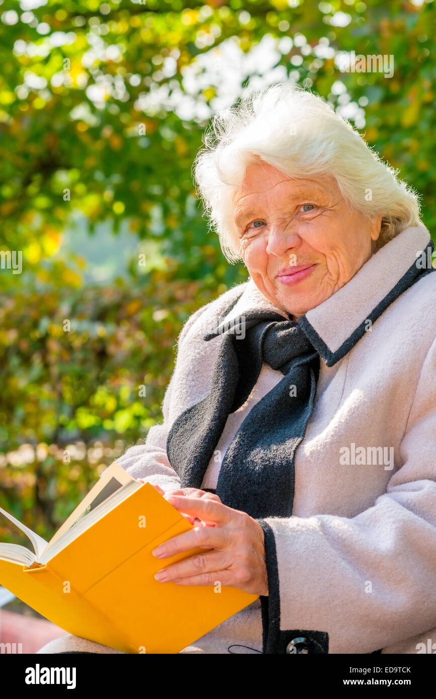 Ritratto di una nonna felice su una panchina nel parco Foto Stock