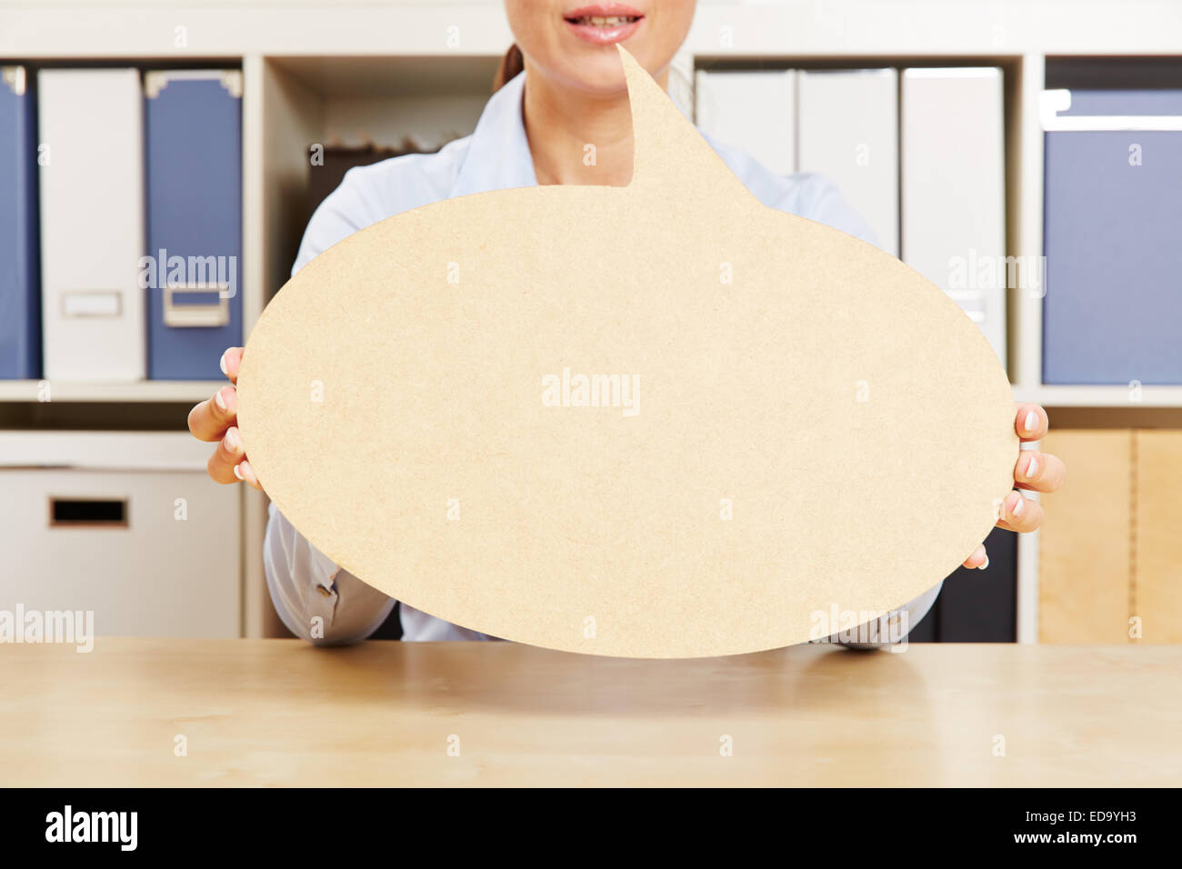 La donna in un ufficio di trattenimento di un vuoto discorso bolla di fronte la sua bocca Foto Stock