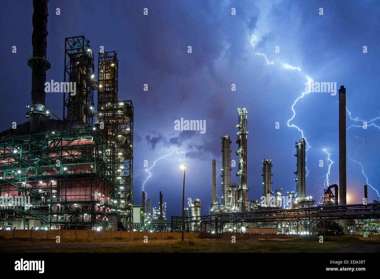 Il fulmine colpisce le viti di raffineria di petrolio a industrial estate durante il forte temporale quadro concettuale per il riscaldamento globale Foto Stock