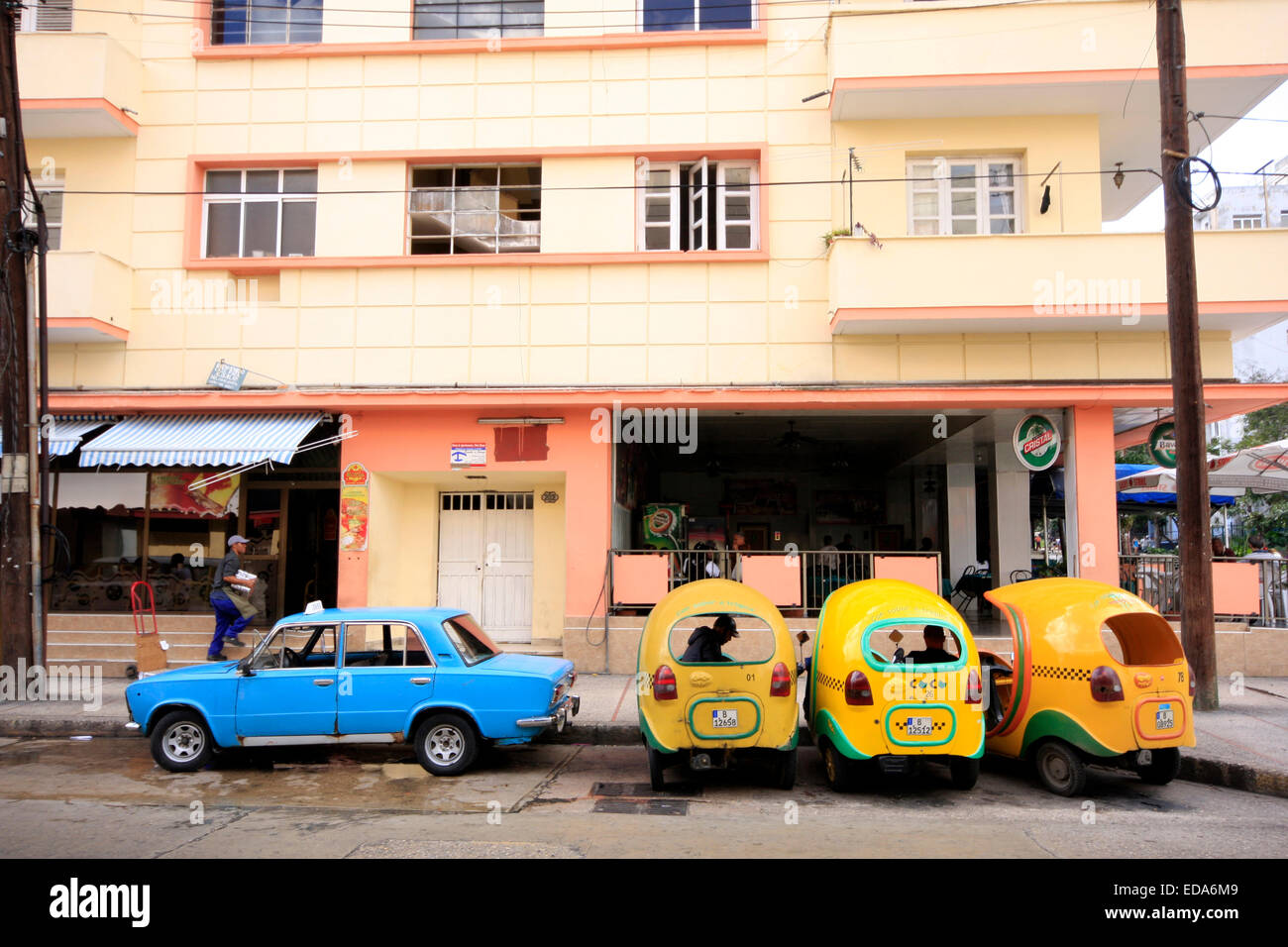 Il vecchio e il nuovo in Havana - un russo fatto Lada parcheggiate accanto a coco taxi in una strada della capitale cubana Foto Stock