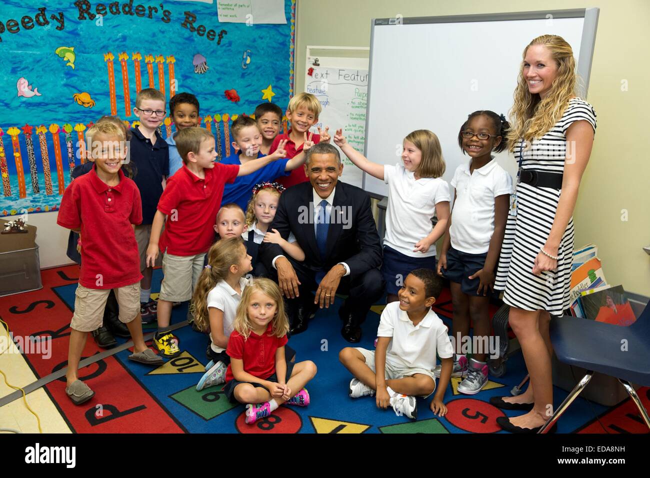 Il Presidente Usa Barack Obama sorrisi come egli si pone per una foto di gruppo con gli studenti della scuola elementare a MacDill Air Force Base di settembre 17, 2014 a Tampa, in Florida. Il Presidente scherzosamente ha detto agli studenti di non fare orecchie di coniglio dietro di lui che non potevano resistere alla tentazione di fare. Foto Stock