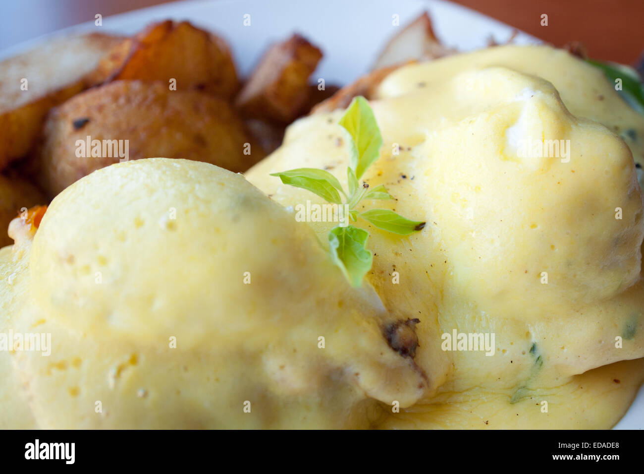 Un close-up di Uova Benedict coperti in salsa olandese. Foto Stock