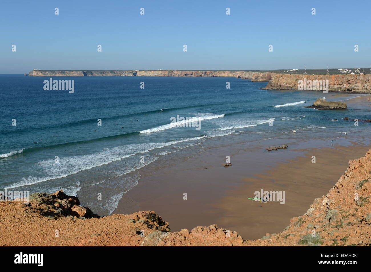 Perfette condizioni di surf a Tonel Beach Sagres con Capo San Vincenzo faro in background Foto Stock