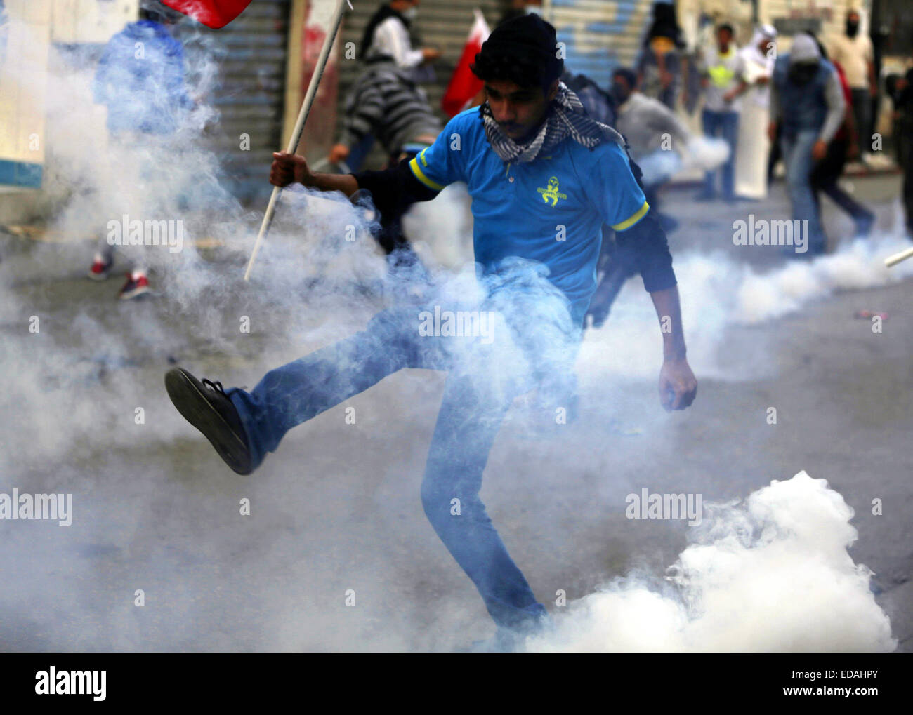 Manama, Bahrain. 3 gennaio, 2015. Un Bahraini anti-government protester trattative con gas lacrimogeni sparati da anti-sommossa poliziotti durante lo scontro in Bilad Al Qadeem, vicino a Manama, la capitale del Bahrein, Gen 3, 2015. Scontro ha eruttato in molte parti del Bahrain tra anti-sommossa polizia e dimostranti che chiedono la liberazione del paese sciita principale leader dell opposizione lo sceicco Ali Salman. © Hasan Jamali/Xinhua/Alamy Live News Foto Stock