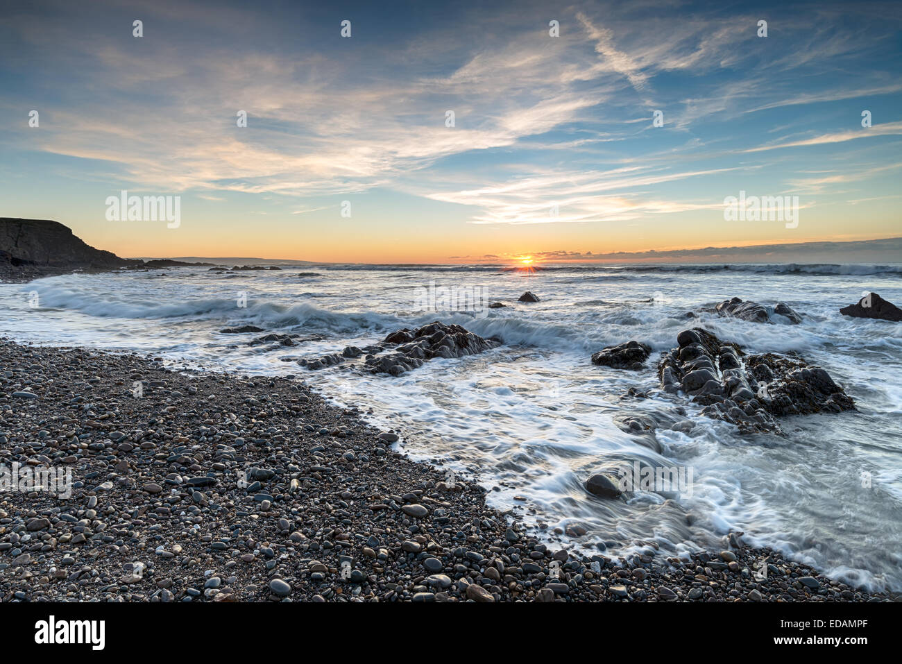 Tramonto sopra le onde e le rocce a bocca Northcott spiaggia vicino a Bude in Cornovaglia Foto Stock