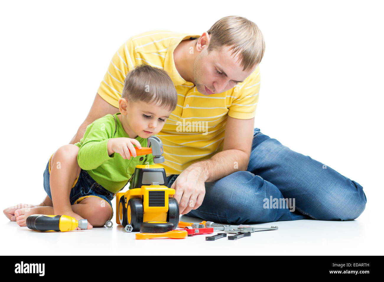 Il bambino e il suo papà riparare il trattore giocattolo Foto Stock
