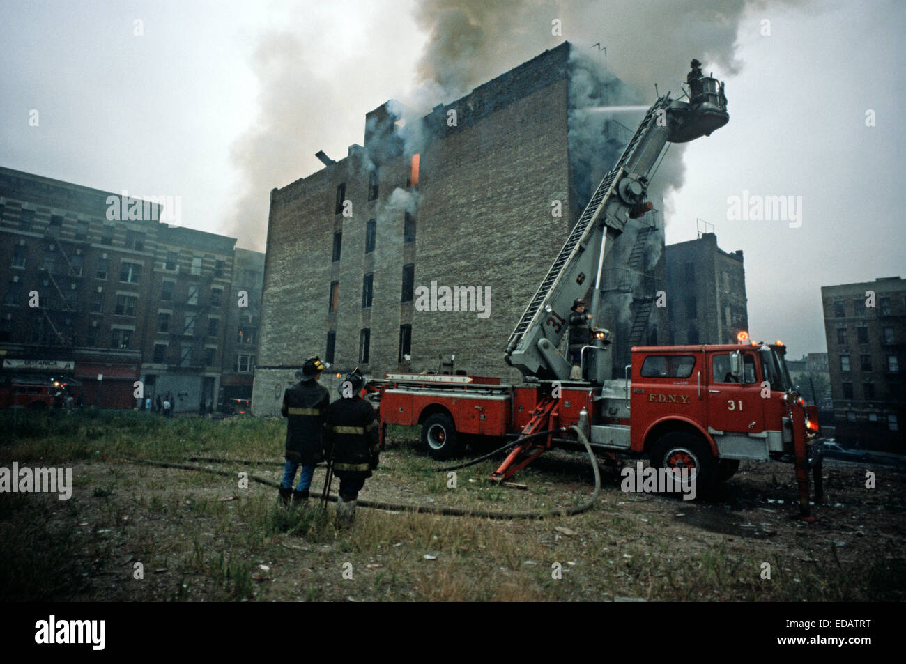 Stati Uniti d'America, Sud Bronx, NEW YORK CITY - agosto 1977. New York City per i vigili del fuoco di combattere il fuoco nel Sud Bronx abbandonato casamento. Foto Stock