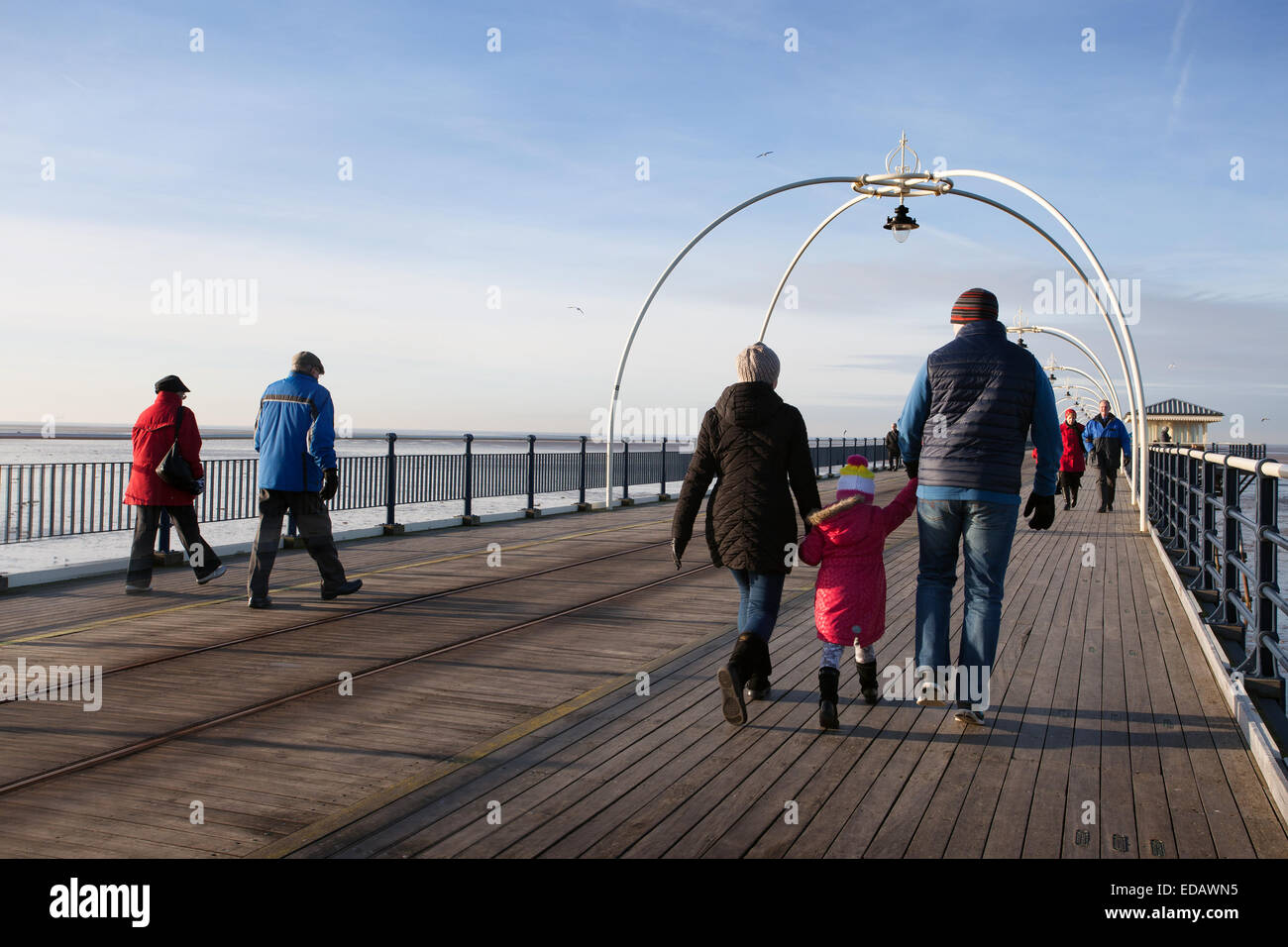 Southport, Merseyside Regno Unito 4 gennaio, 2014. Regno Unito Meteo. Cieli soleggiati sulla costa nord-ovest come weekenders promenade all'annata, ma restaurato. Il Grade ii Listed Southport Pier. Esso è il più antico molo di ferro nel paese, avendo superato per oltre 150 anni sul lungomare. Credito: Mar fotografico/Alamy Live News Foto Stock