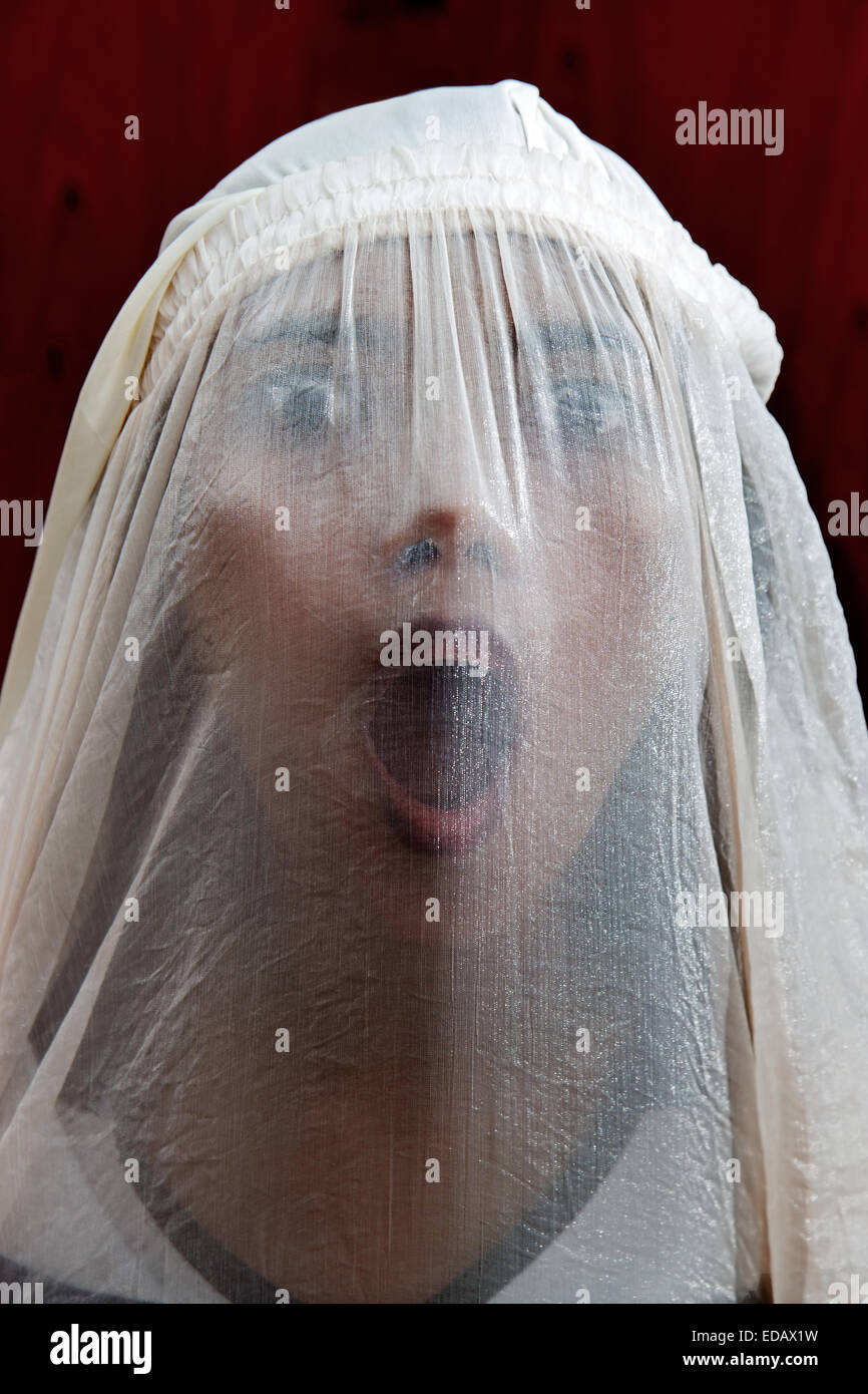 Ritratto di una ragazza urlando dietro il velo Foto Stock