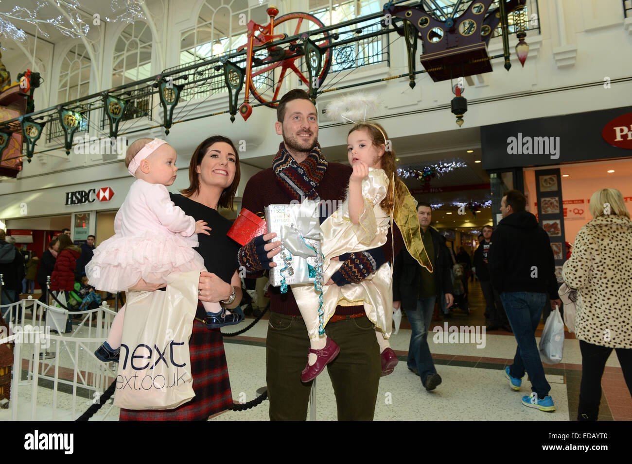 Shopping in famiglia per regali di natale al Telford Town Centre UK coppia con bambini. Negozi 2014 Gran Bretagna cacciatore di affare britannico Foto Stock