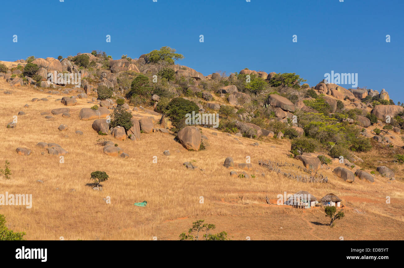 HHOHHO, SWAZILAND, AFRICA - insediamento rurale, le case e gli edifici e la cresta con roccia che affiora in superficie. Foto Stock