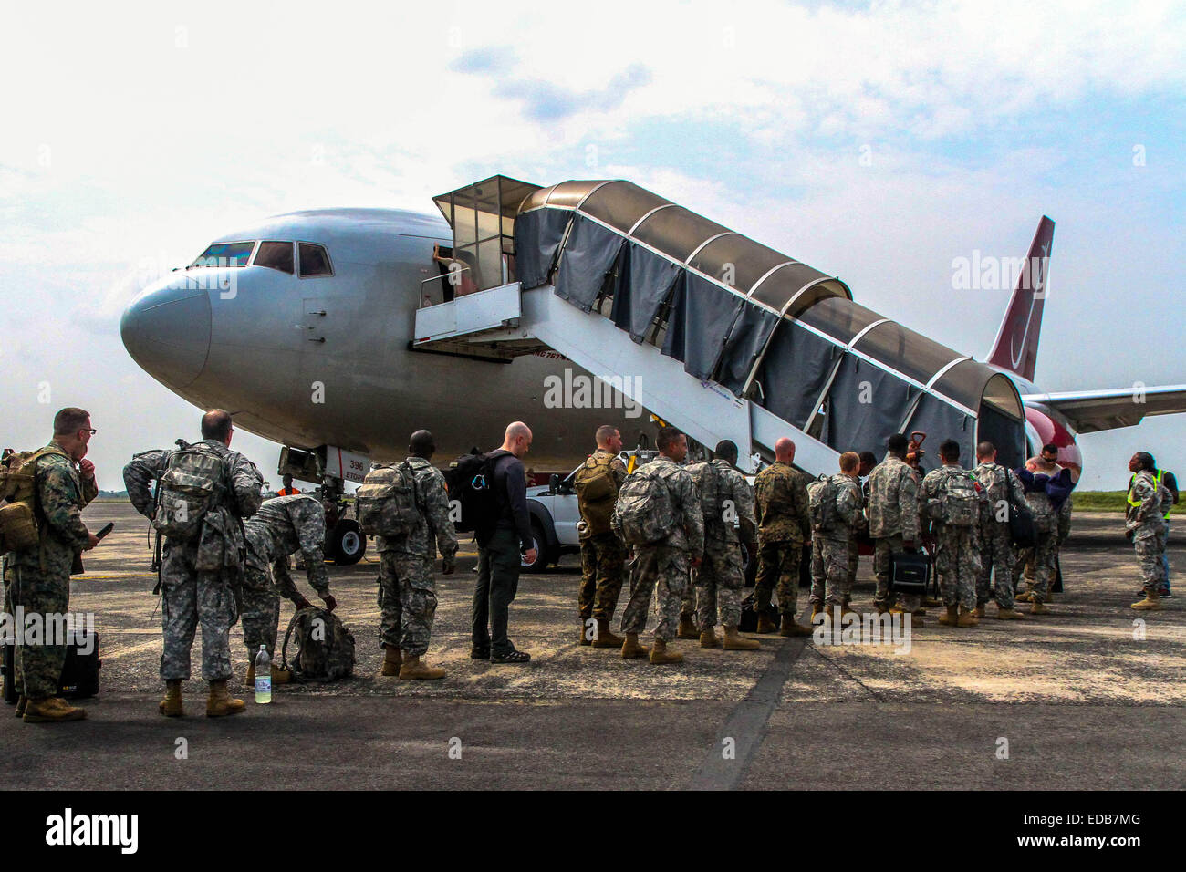 Noi membri di servizio a bordo di un aeromobile come essi partono dopo il completamento dell'operazione di assistenza unita a contribuire alla lotta contro il virus di Ebola a Roberts Aeroporto Internazionale Gennaio 2, 2015 a Monrovia, Liberia. Tutte le truppe saranno monitorati per 21 giorni per impedire la diffusione del virus al ritorno negli Stati Uniti. Foto Stock