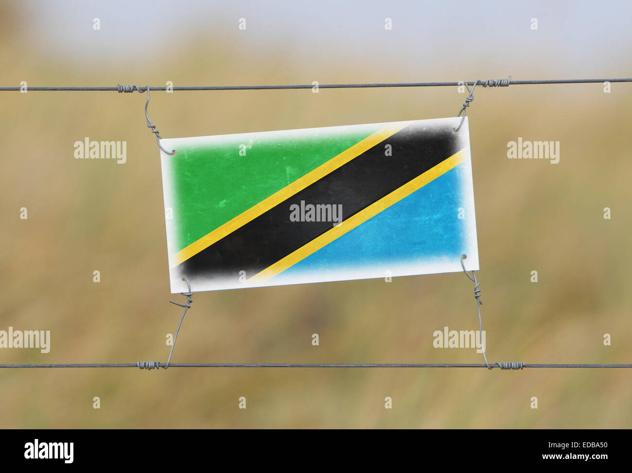 Recinzione di confine - il vecchio segno di plastica con un flag - Tanzania Foto Stock