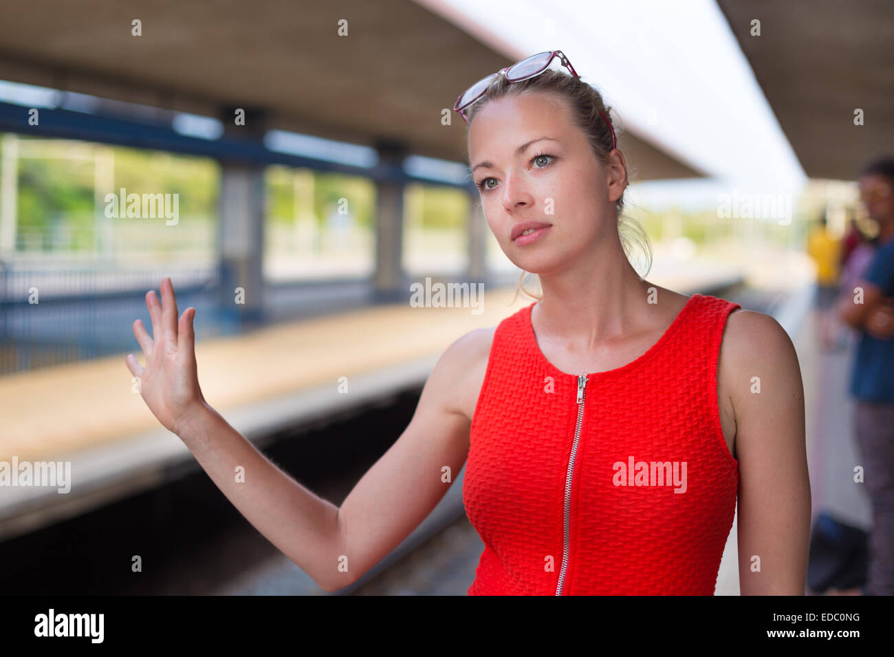 Giovane donna sulla piattaforma della stazione ferroviaria. Foto Stock