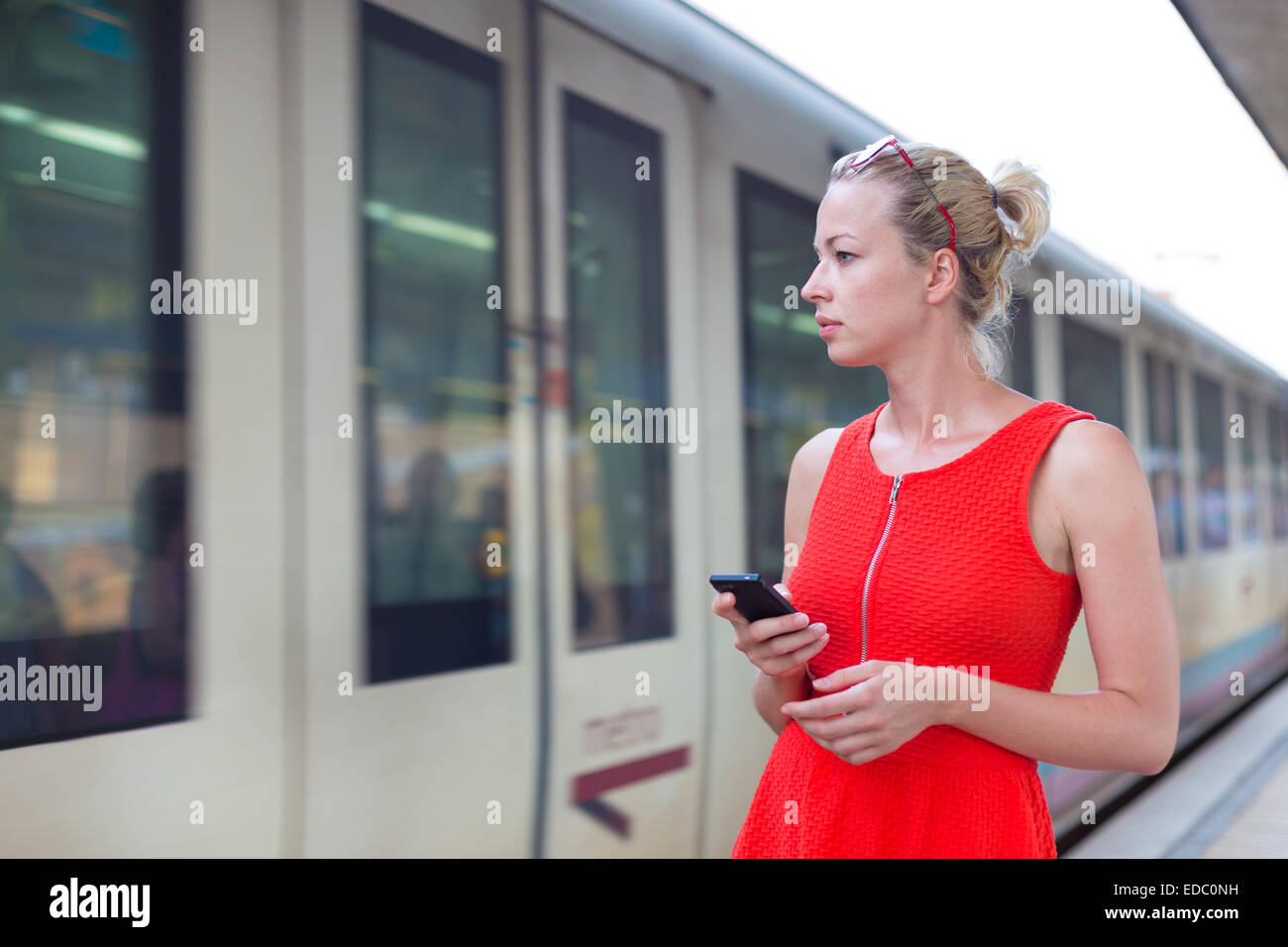 Giovane donna sulla piattaforma della stazione ferroviaria. Foto Stock