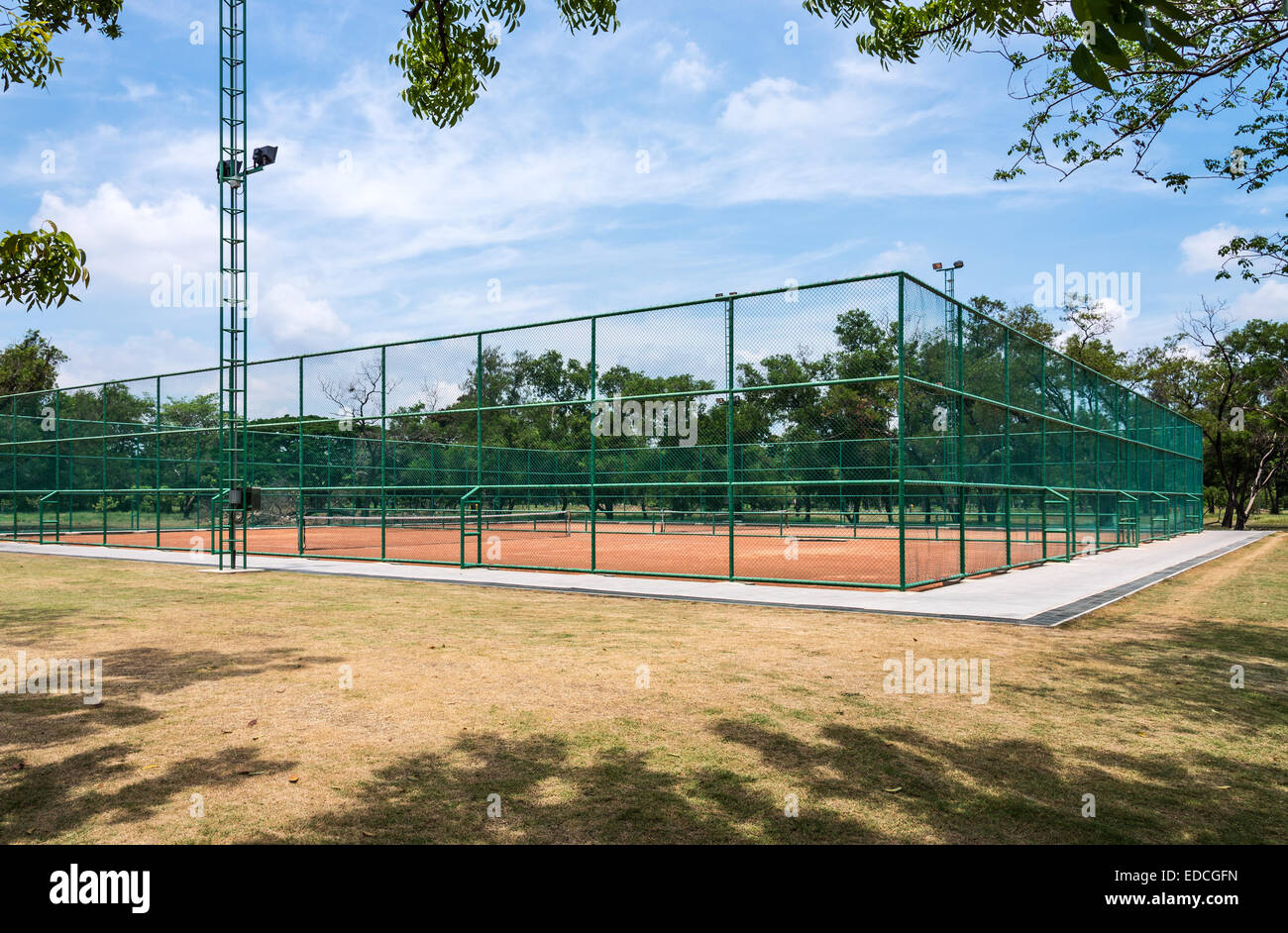 Campo da tennis in terra battuta nel parco urbano della Thailandia. Foto Stock