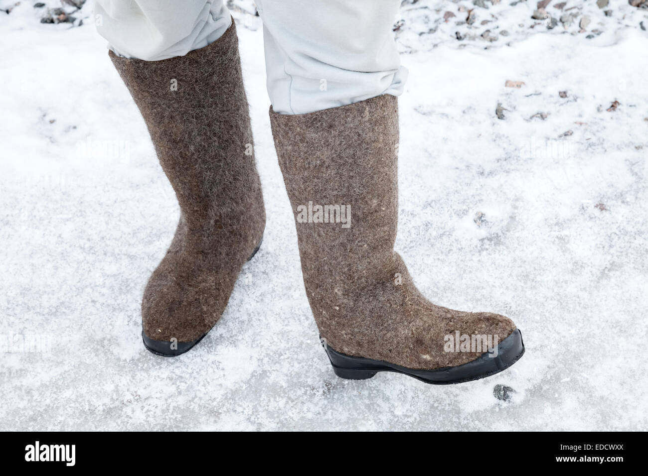 Piedini maschio con Russo stivali di feltro su strada in inverno con neve e ghiaccio Foto Stock