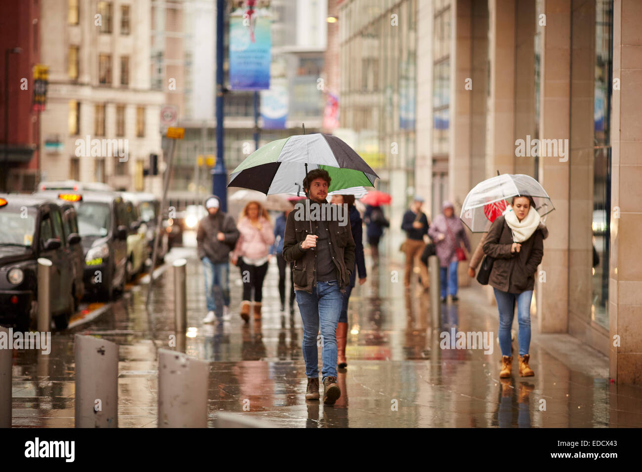 Shopping sotto la pioggia a Manchester REGNO UNITO Foto Stock