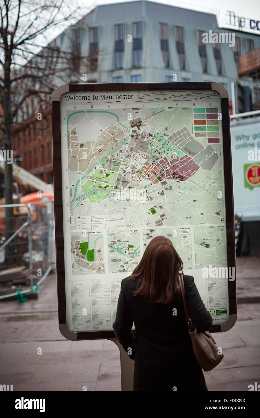 Una signora guardando la mappa stradale di Manchester City Centre Foto Stock