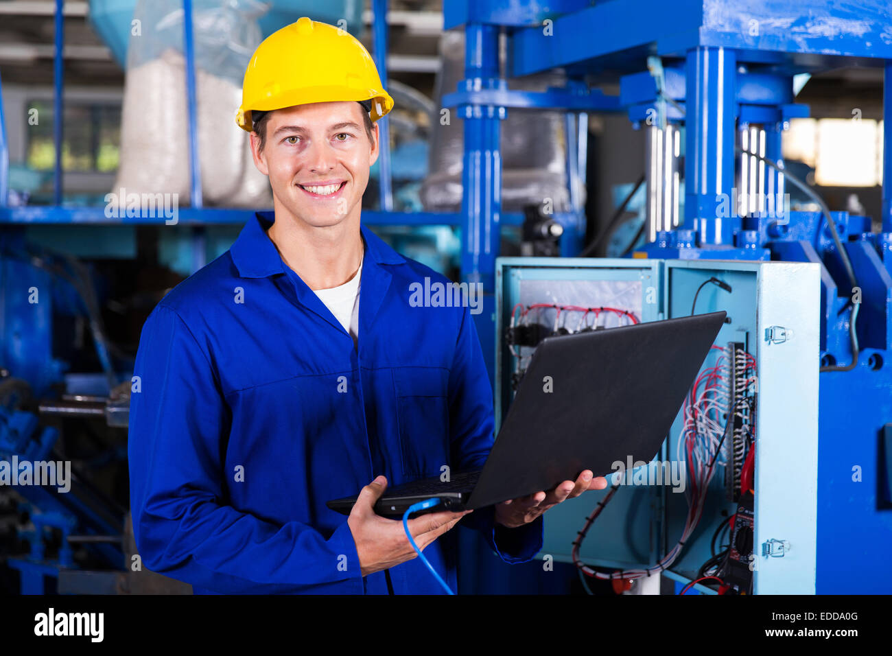 Ritratto di ingegnere maschio con computer portatile in fabbrica Foto Stock