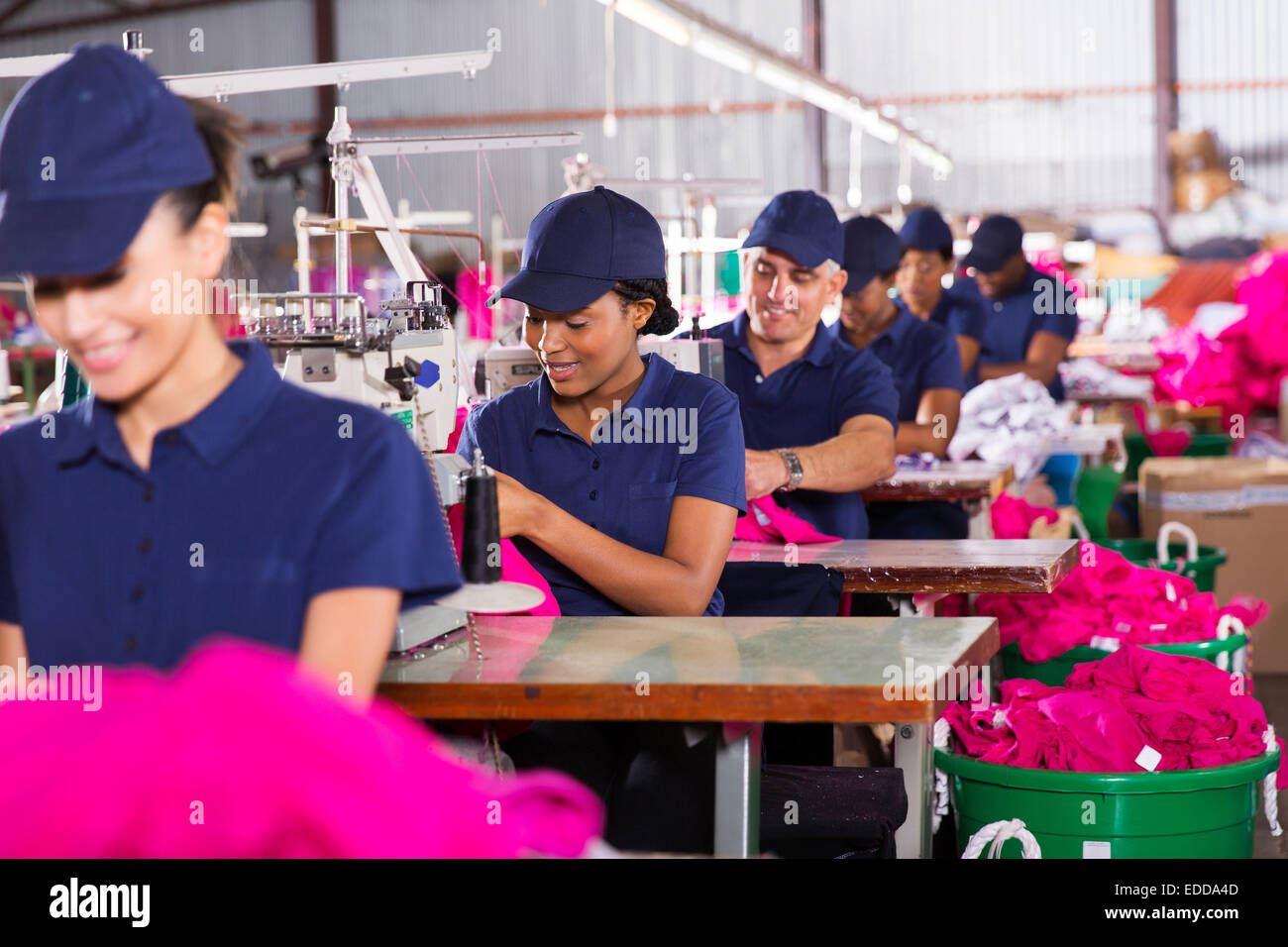 Gruppo multirazziale lavoratori in fabbrica la cucitura in fabbrica di abbigliamento Foto Stock