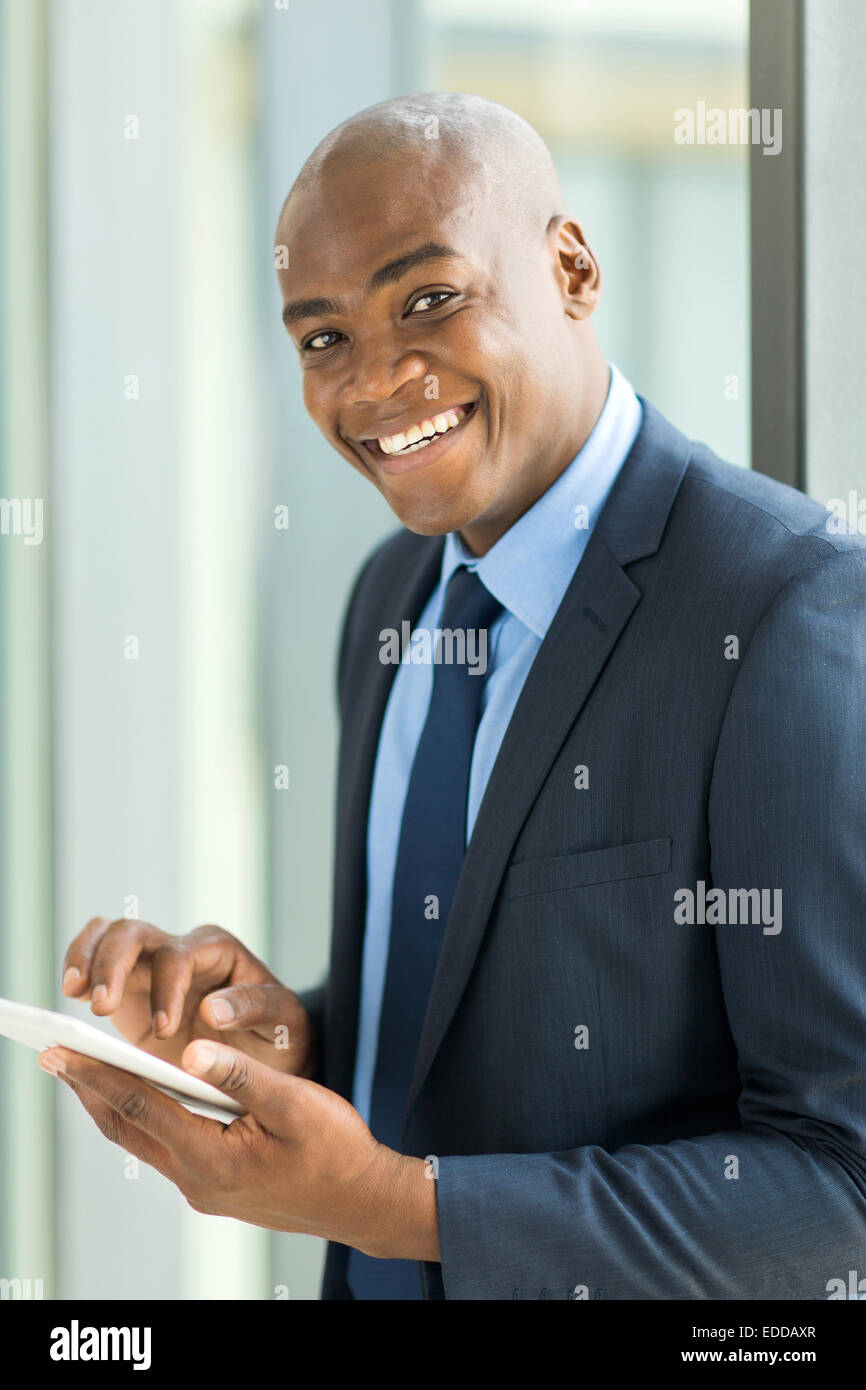 Allegro imprenditore nero con Tablet PC in ufficio moderno Foto Stock