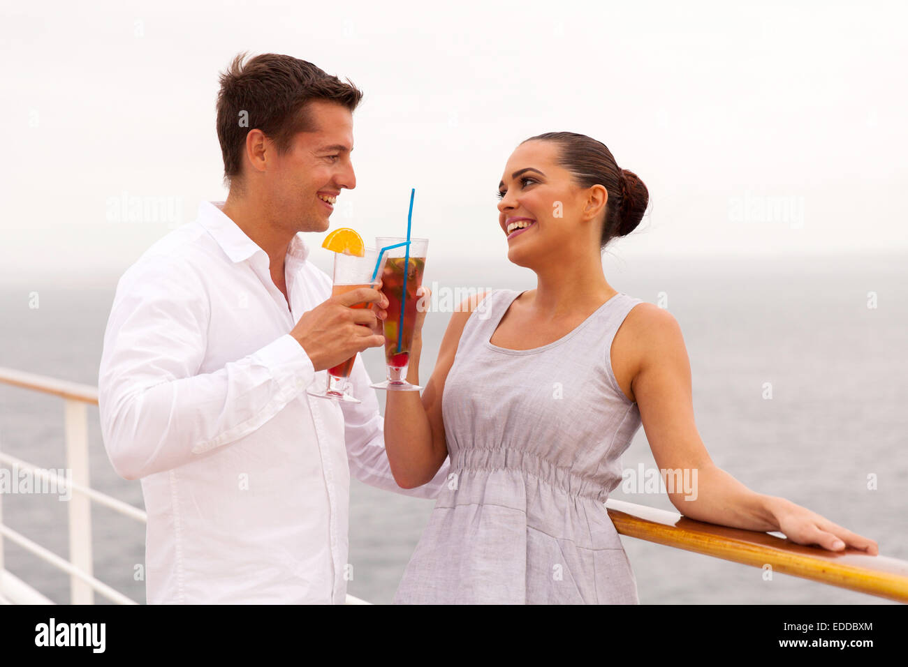 Felice coppia sposi in luna di miele a bere un cocktail su una nave da crociera Foto Stock