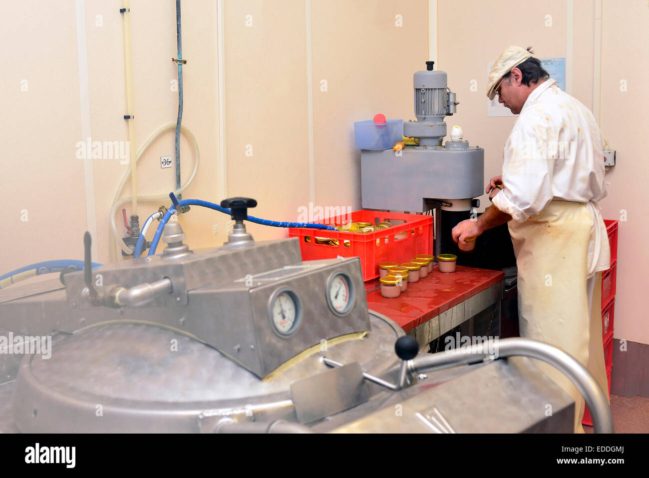 Uomo di funzionamento macchina di conservazione in una macelleria Foto Stock