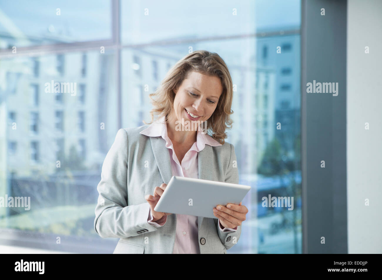 Sorridente imprenditrice utilizzando digitale compressa in office Foto Stock