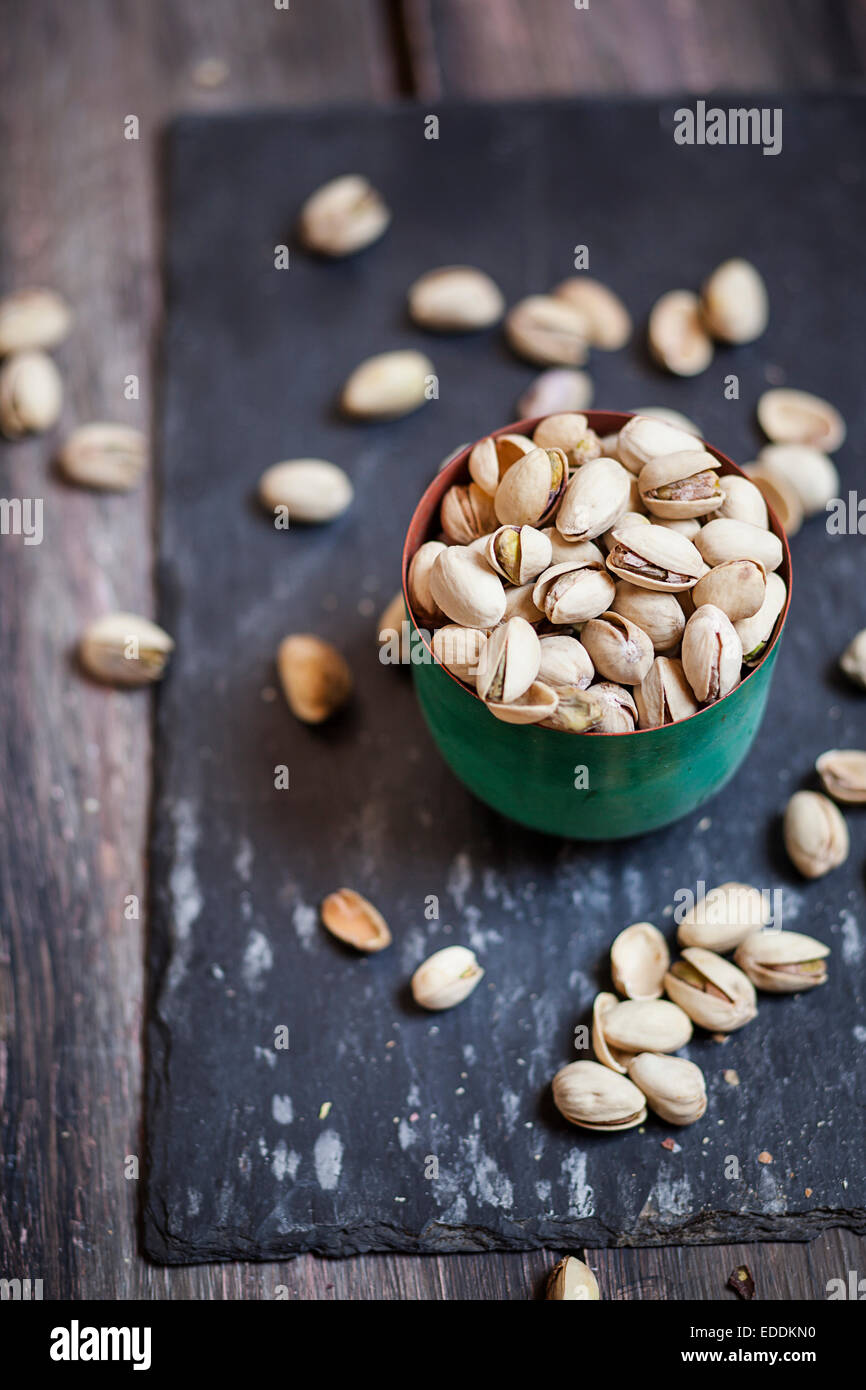 Ciotola di tostati e salati pistacchi sull'ardesia Foto Stock