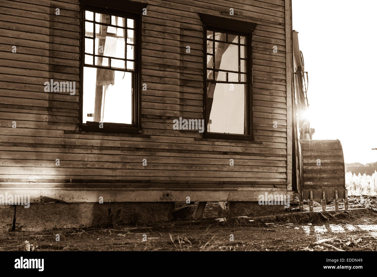 Il braccio di un escavatore meccanico attende di demolire i resti di una casa in Falmouth, Massachusetts - Stati Uniti Foto Stock