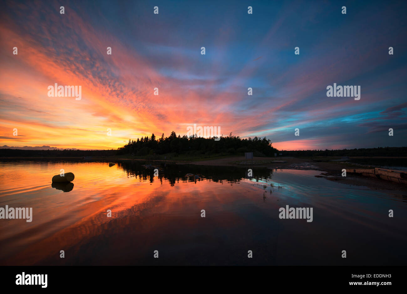 Cielo di tramonto riflesso in un lago, e nuvole nel cielo. Foto Stock