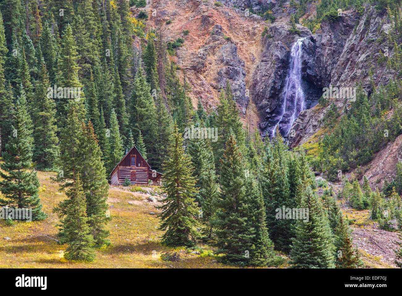 Cabina e cascata lungo il Loop Alpine road nelle montagne di San Juan di Colorado Foto Stock